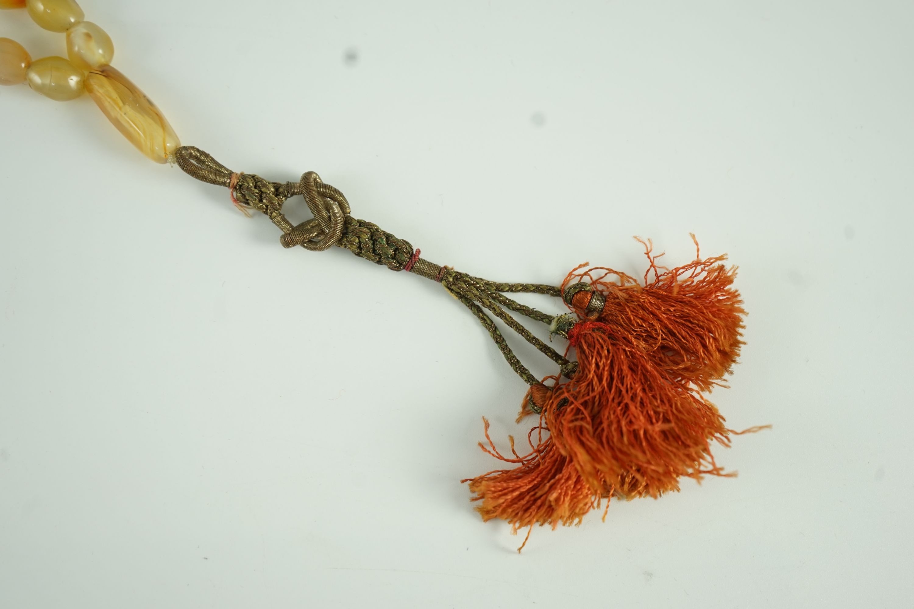 A Sino-Tibetan row of agate prayer beads, 19th century Total drop including tassel 36 cm